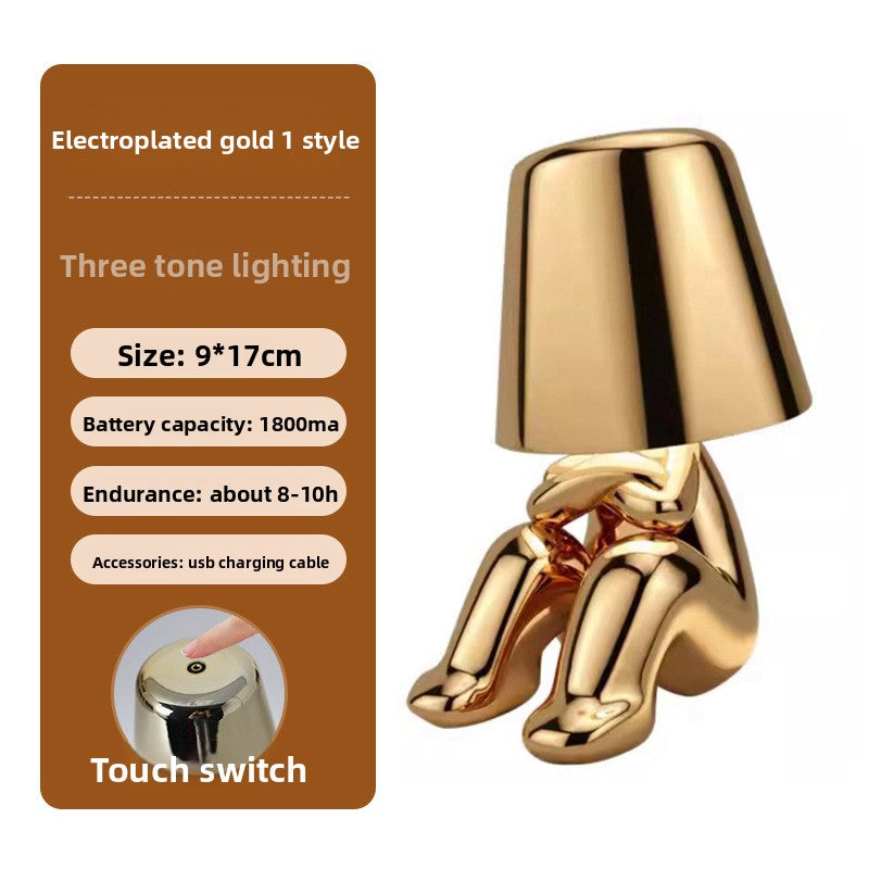 Tischlampe mit goldfarbener Figur